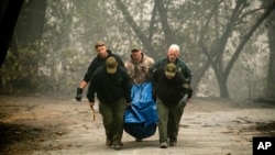 Sheriff's deputies recover the remains of a victim of the Camp Fire, Nov. 10, 2018, in Paradise, California.