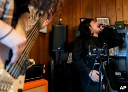 Camara, now 27, had difficulty paying tuition and finding time to do schoolwork while caring for his younger sister. "I seriously tried," he said. "I gave it my all." For now, Camara is happy working as a sous-chef and cook at a local restaurant while planning a tour with one of his two bands. (AP Photo/Lindsey Wasson)