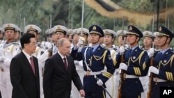 Presiden Rusia Vladimir Putin (dua dari kiri) berdampingan dengan Presiden Tiongkok Hu Jintao (kiri) disambut dengan upacara penghormatan dalam pertemuan puncak regional 'Shanghai Cooperation Organizatio (SCO)' di Beijing (6/5).