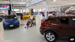  Visitors walk around at a Toyota showroom in Tokyo, Jan. 30, 2017. Toyota plans to invest $10 billion in the U.S. in the next five years.