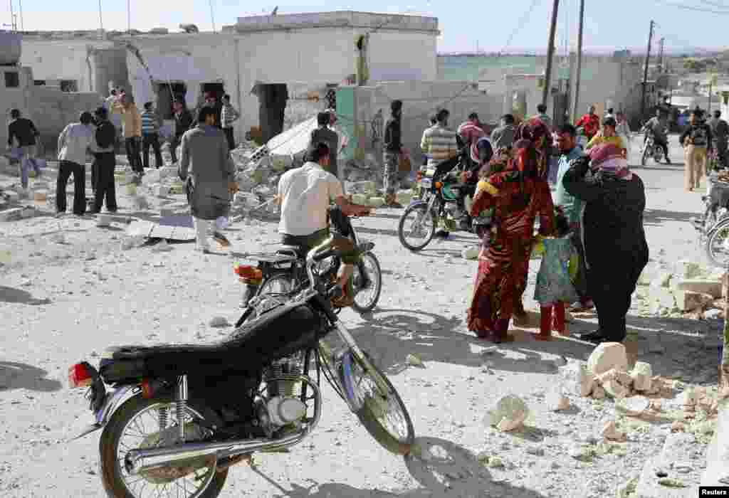 People inspect a site hit by what activists said were barrel bombs dropped by forces loyal to President Bashar al-Assad, in al-Letmana village, Hama province, May 1, 2014.&nbsp;