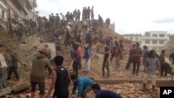 Volunteers help with rescue work at the site of a building that collapsed after an earthquake in Kathmandu, Nepal, Saturday, April 25, 2015.