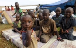 FILE - Burundian refugee children pose for a photograph at the Lake Tanganyika stadium in Kigoma western Tanzania, May 19, 2015.
