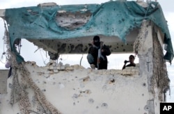 An Afghan security man stands guard at police station after clashes between the Afghan police and Taliban militants at a police station in the city of Kandahar, south of Kabul, Afghanistan, Tuesday, Dec. 8, 2015.