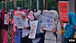 Massa dari sejumlah ormas Islam membawa berbagai tulisan dalam aksi menolak Perppu Ormas di depan gedung DPR RI, Selasa 24/10 (Ahadian/VOA).