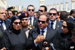 In this picture taken June 30, 2015, and provided by the office of the Egyptian Presidency, Egyptian president Abdel-Fattah el-Sissi (C) speaks at the funeral for Hisham Barakat, surrounded by the latter's family members.