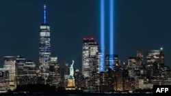 Patung Liberty di New York berhiaskan sinar lampu dalam peringatan 11 September 2021. （ROBERTO SCHMIDT / AFP)