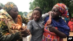 Seorang siswa yang diculik dan kemudian dibebaskan dipertemukan kembali dengan keluarganya di Bethel Baptist High School di Damishi, Nigeria, pada Minggu, 25 Juli 2021. (Foto: AP)