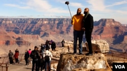 Visitors to the Grand Canyon take selfies with a cell phone on Dec. 6, 2019. (Photo by Hai Do)