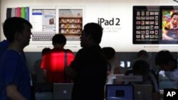 Para pengunjung di sebuah gerai Apple di Beijing (2/7). Apple membayar 60 juta dolar untuk menggunakan merek dagang iPad di Tiongkok.