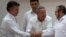 FILE - Cuba's President Raul Castro (C) encourages Colombian President Juan Manuel Santos (L) and Commander the Revolutionary Armed Forces of Colombia or FARC, Timoleon Jimenez, to shake hands, in Havana, Cuba, Sept. 23, 2015. 