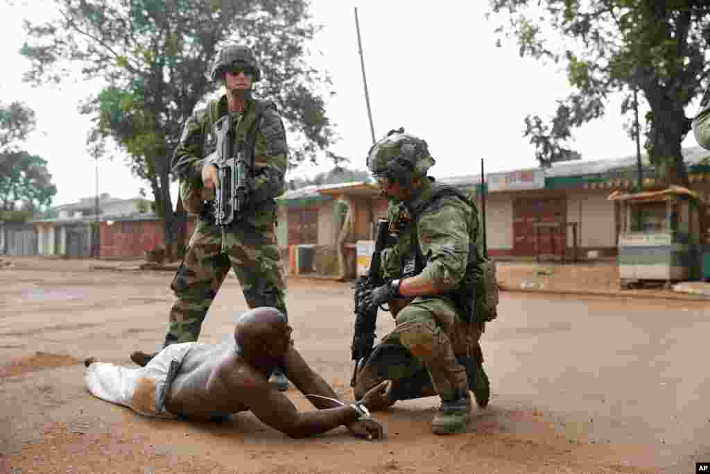 French troops detain a suspected Seleka officer, preventing mobs from lynching him near the airport in Bangui, Central African Republic, Dec. 9, 2013. 
