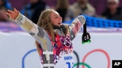 Jamie Anderson of the United States celebrates on the way to the flower ceremony after winning the women's snowboard slopestyle final at the 2014 Winter Olympics, Sunday, Feb. 9, 2014, in Krasnaya Polyana, Russia. 