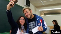 Pemilih di Barcelona, Spanyol mengambil foto selfie saat memilih (foto: ilustrasi). Sebagin besar negara bagian AS melarang foto selfie dari bilik suara pemilu.