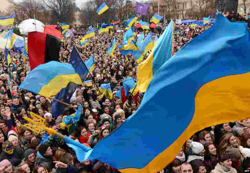 Para demonstran Ukraina pro Uni Eropa melambai-lambaikan bendera Ukraina dalam unjuk rasa di kota Lviv. 