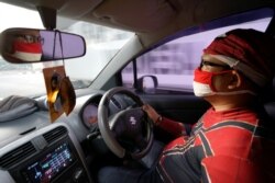 Agus Widanarko, 40, mengenakan kostum Spiderman saat mengemudi saat bersiap menghibur anak-anak yang terkurung di rumah akibat pembatasan COVID-19, di Sukoharjo, Jawa Tengah, 10 September 2021. (Foto: Reuters)