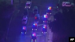 In this image made from aerial video, police vehicles block an intersection in the vicinity of a shooting in Thousand Oaks, California, early Nov. 8, 2018. Authorities say there were multiple injuries, including one officer.