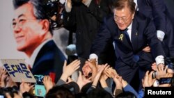 문재인 한국 대통령 당선인이 9일 서울 광화문 광장에 모인 지지자들의 손을 잡아주고 있다.