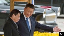 Chinese President Xi Jinping, right, and Philippine President Rodrigo Duterte are seen during a welcome ceremony outside the Great Hall of the People in Beijing, China, Oct. 20, 2016.