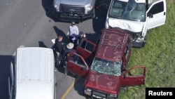 Law enforcement personnel investigate the scene where the Texas bombing suspect blew himself up on the side of a highway north of Austin in Round Rock, Texas, March 21, 2018. 