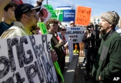 FILE - Donald Trump protesters argue with a supporter outside the Holiday Inn Express prior to a scheduled appearance by the Republican presidential candidate in Janesville, Wisconsin, March 29, 2016.