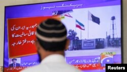 مردی مقابل صفحه تلویزیون در کراچی سرگرم تماشای «خبر فوری»؛ وزارت امور خارجه پاکستان گفت این کشور به «شبه‌نظامیان جدایی‌طلب» در داخل ایران حمله کرده است.
