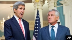 Secretary of State John Kerry (L), joined by Defense Secretary Chuck Hagel, speaks to media at the State Department in Washington, Oct. 24, 2014.