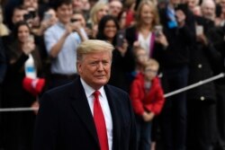 FILE - President Donald Trump pauses in front of reporters as he and first lady Melania Trump prepare to board Marine One on the South Lawn of the White House in Washington, Jan. 13, 2020.