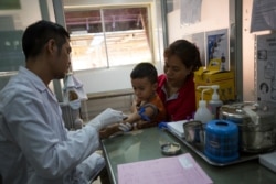 កុមារដែលជាអ្នកជំងឺម្នាក់កំពុងត្រូវបានគ្រូពេទ្យបូមឈាមយកទៅពិនិត្យមើលមេរោគគ្រុនឈាម នៅមន្ទីរពេទ្យកុមារអង្គរ ខេត្តសៀមរាប។