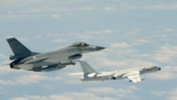 This handout photograph taken and released on May 11, 2018 by Taiwan's Defence Ministry shows a Republic of China (Taiwan) Air Force F-16 fighter aircraft (L) flying alongside a Chinese People's Liberation Army Air Force (PLAAF) H-6K bomber.