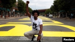 Ricco Wright poses for a photo on a street painted with a 'Black Lives Matter' message to mark Juneteenth, which commemorates the end of slavery in Texas. (REUTERS/Shannon Stapleton)