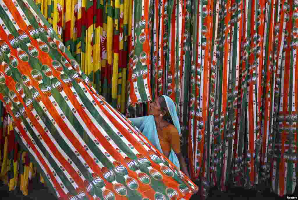 Seorang pekerja India menggulung bendera Partai Kongres menjelang pemilu di kota Ahmedabad.&nbsp;