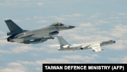 This handout photograph taken and released on May 11, 2018 by Taiwan's Defense Ministry shows a Republic of China (Taiwan) Air Force F-16 fighter aircraft (L) flying alongside a Chinese People's Liberation Army Air Force (PLAAF) H-6K bomber that entered its airspace.