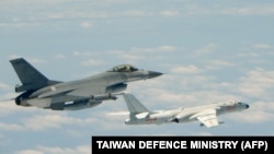 Foto selebaran yang diambil dan dirilis pada 11 Mei 2018 oleh Kementerian Pertahanan Taiwan ini menunjukkan sebuah pesawat tempur F-16 (kiri) Angkatan Udara Republik China (Taiwan) terbang bersama pesawat pengebom H-6K Angkatan Udara Pembebasan Rakyat China (PLAAF). (Foto: 