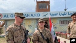 In this March 27, 2020 file photo, US soldiers stand guard during the handover ceremony of Qayyarah Airfield in the south of Mosul, Iraq.