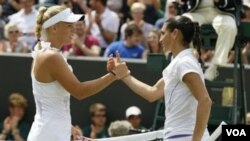 Petenis Denmark Caroline Wozniacki bersalaman setelah mengalahkan petenis Perancis Virginie Razzano di Wimbledon, Jumat (24/6).