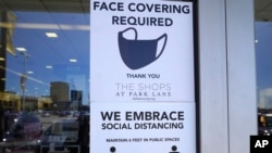 Pengumuman untuk menggunakan masker sebagai pencegahan infeksi COVID-19 ditempel di sebuah jendela toko, di Dallas, Texas, 2 Maret 2021. (Foto: AP/LM Otero)