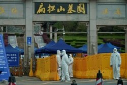 People wearing protective suits are seen in Biandanshan cemetery in Wuhan, Hubei province, the epicenter of China's coronavirus disease outbreak, April 1, 2020.