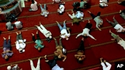 FILE - Muslim men nap as they wait for the time to break their fast after Friday prayer at the Istiqlal Mosque in Jakarta, Indonesia, Friday, June 9, 2017. Muslims across the world are observing the holy fasting month of Ramadan, where they refrain from eating, drinking and smoking from dawn to dusk. (AP Photo/Tatan Syuflana)