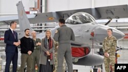 Waziri Mkuu wa Ubelgiji Alexander De Croo, Rais wa Ukraine Volodymyr Zelensky na Waziri wa Ulinzi wa Ubelgiji Ludivine Dedonder wakisikiliza walipokutana na marubani wa Ubelgiji wa F-16, wakufunzi na wafanyakazi wa kiufundi wakati wa ziara ya ukaguzi
