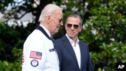 Presiden AS Joe Biden, yang mengenakan jaket timnas AS, berjalan bersama putranya Hunter Biden di Gedung Putih, Washington, pada 26 Juli 2024. (Foto: AP/Susan Walsh)