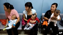 中国妇女抱着孩子等着看医生（美联社2007年9月5日资料照）