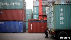一名韩国司机在仁川港货运码头检查一个“中国海运”的集装箱。（2016年5月26日）