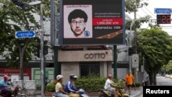 ពលរដ្ឋ​ថៃ​កាល​ពី​ថ្ងៃ​អាទិត្យ​ទី​២៣​ខែ​សីហា ​ជិះ​ម៉ូតូ​កាត់​ប៉ាណូ​ឌីជីថល​មួយ​ដែល​មាន​បង្ហាញ​គំនូរ​ព្រាង​​នៃ​ជន​សង្ស័យ​សំខាន់​​​​​ដែល​ទទួល​ខុស​ត្រូវ​នៅ​ក្នុង​ការ​បំផ្ទុះ​គ្រាប់​បែក​កាល​ពី​ថ្ងៃ​ច័ន្ទ​សប្តាហ៍​មុន។