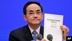 Xu Lin, Vice head of the Publicity Department of Communist Party, shows a copy of the white paper on fighting COVID-19 China during a press conference at the State Council Information Office in Beijing, June 7, 2020.