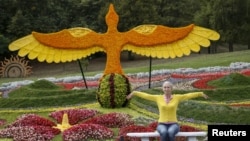 FILE - A woman poses for a picture at a flower exhibition in Kyiv, Ukraine, August 21, 2015. (REUTERS/Gleb Garanich)