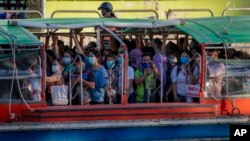 អ្នក​ដំណើរពាក់ម៉ាស់ឈរ​ជិត​ៗគ្នាពេល​ជិះទូក​នាល្ងាច​មួយក្នុង​ទីក្រុង​បាងកក​ប្រទេស​ថៃកាលពី​ថ្ងៃទី២០ ឧសភា ឆ្នាំ២០២០។