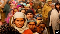 Kashmiris stand in queue to cast their votes outside a polling station during the first phase of voting to the Jammu and Kashmir state assembly elections in Hajan, 35 kilometers (21miles) north of Srinagar, Indian controlled Kashmir, Nov. 25, 2014.