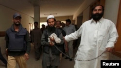 FILE - Police escort a man, identified as Afghan Taliban's top military commander, Mullah Abdul Ghani Baradar.