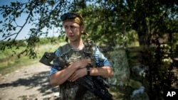 FILE - A Ukrainian soldier is seen guarding a position at the frontline near Avdiivka, Donetsk region, eastern Ukraine, July 19, 2015.